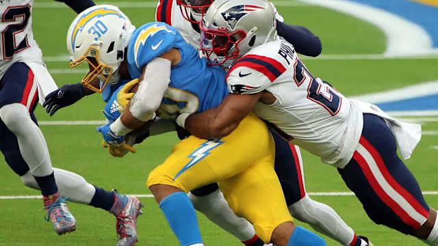 New England Patriots safety Adrian Phillips (21) tackles Los Angeles Chargers RB Austin Ekeler (30) at SoFi Stadium.